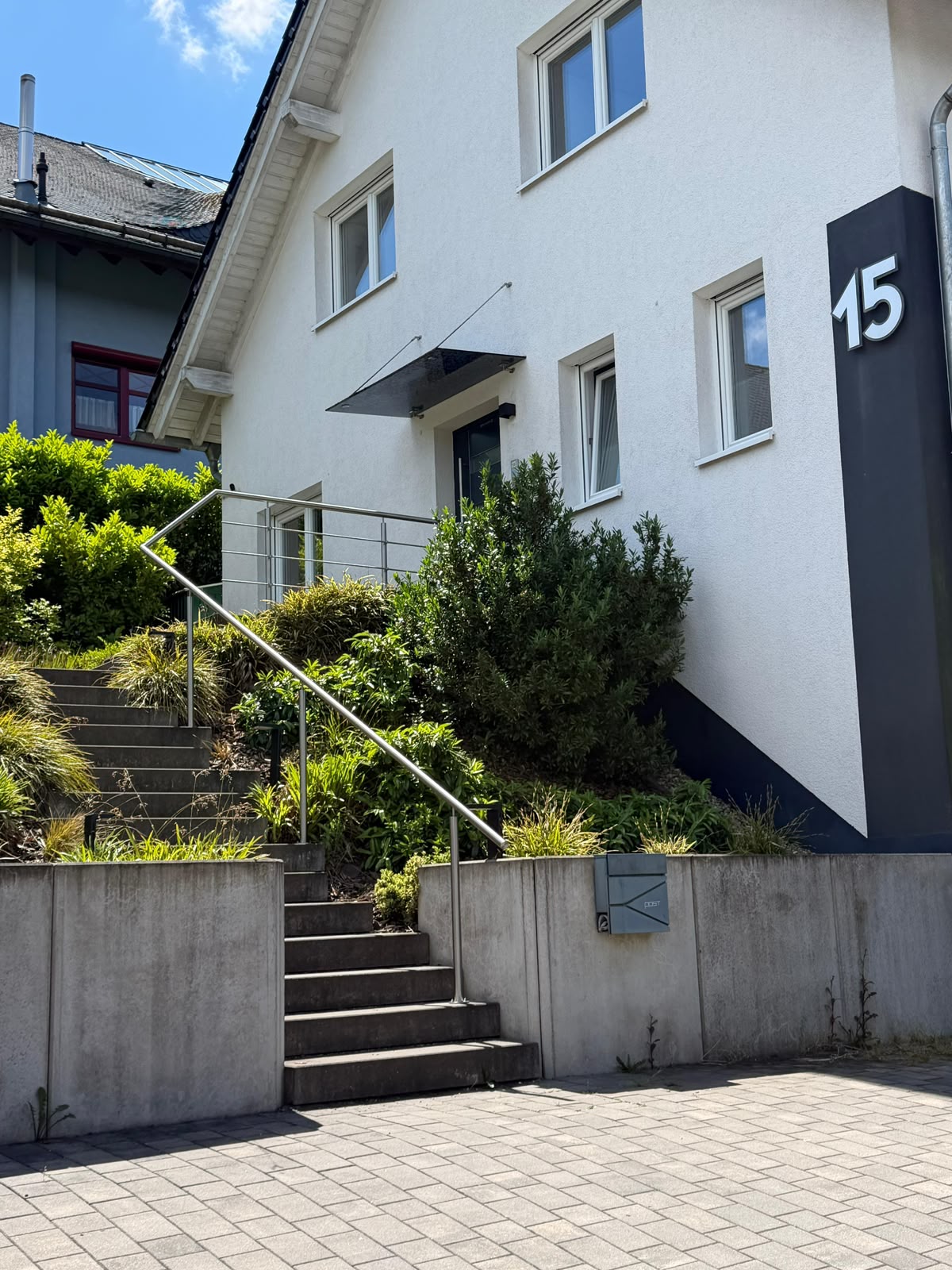 Maßgefertigter Edelstahl-Handlauf an einer Außentreppe am Hauseingang